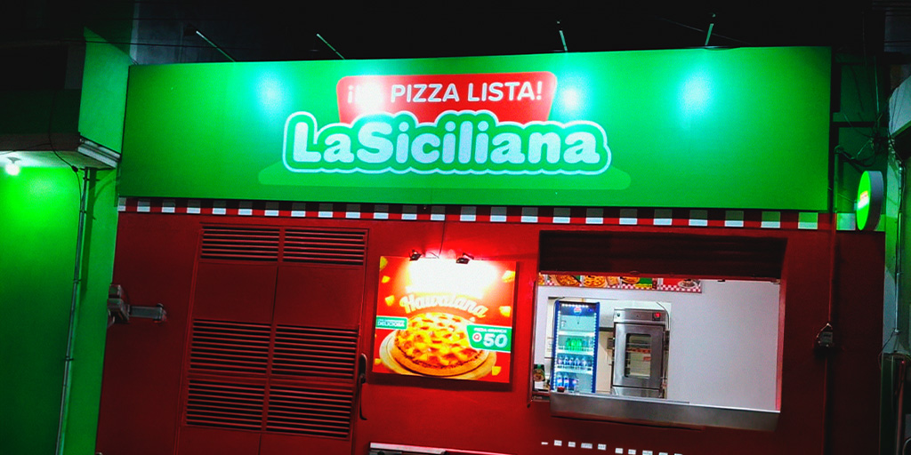 Fachada pizzería La Siciliana con letrero verde neón